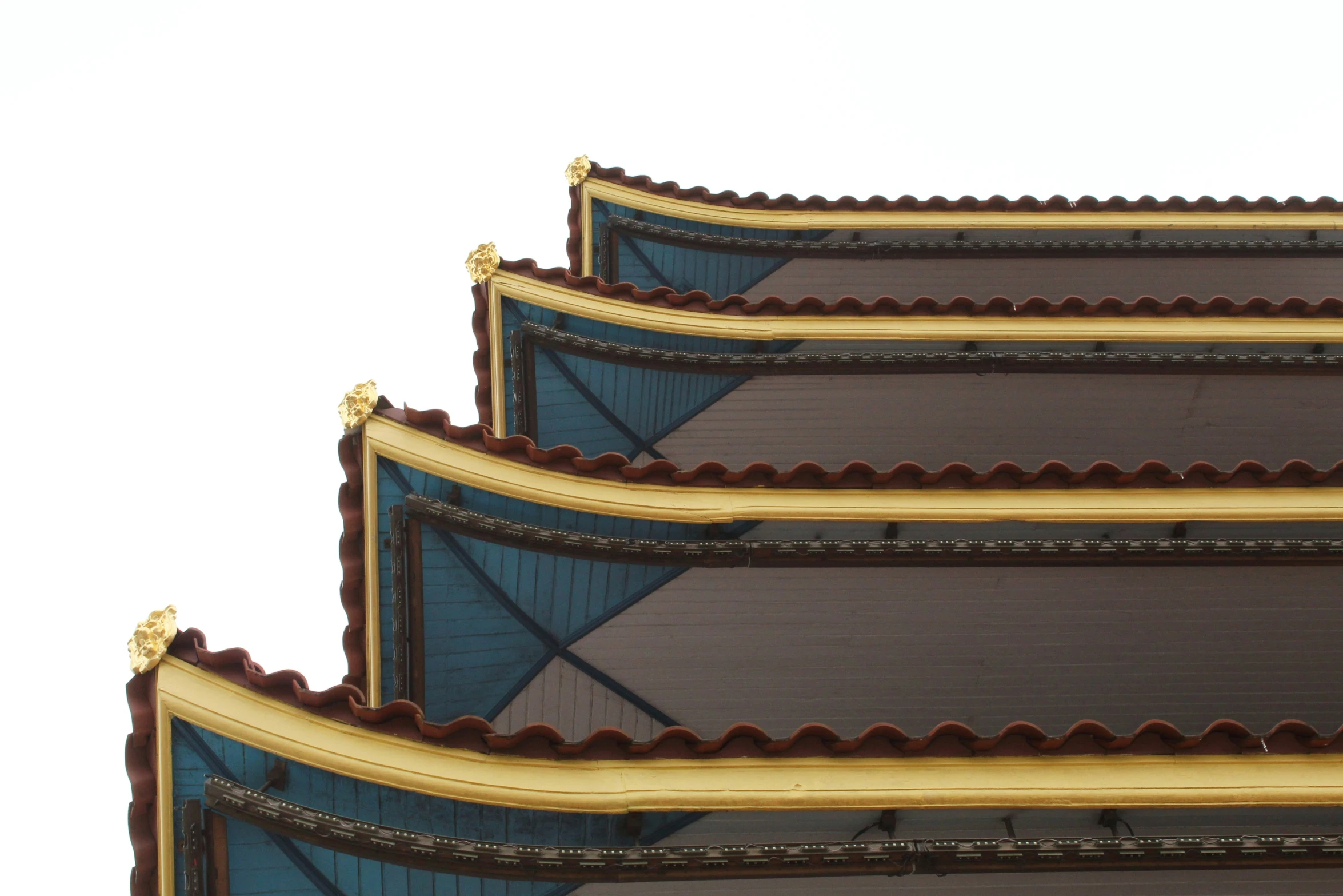 three brown curved buildings that are made of metal