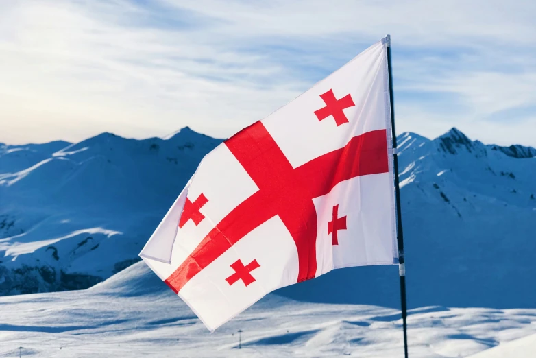 a canadian flag on top of a snow covered mountain