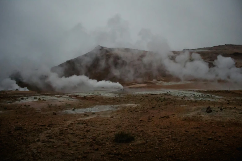 steam vents eruptting from a dry hillside