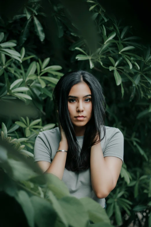 woman looking up from bushes posing for a portrait