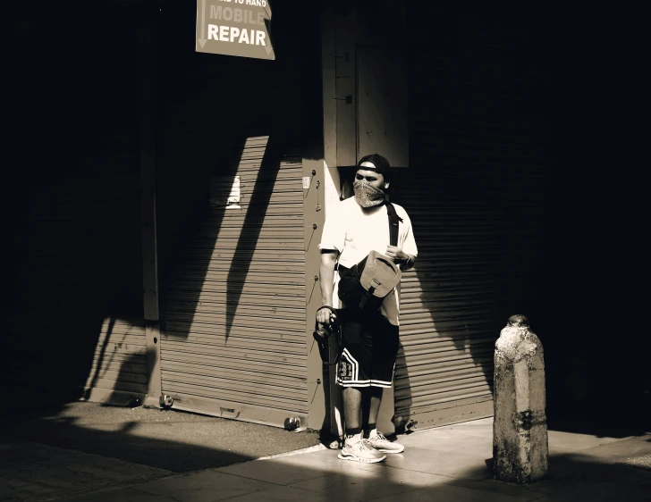 a man standing in front of a building under a street sign