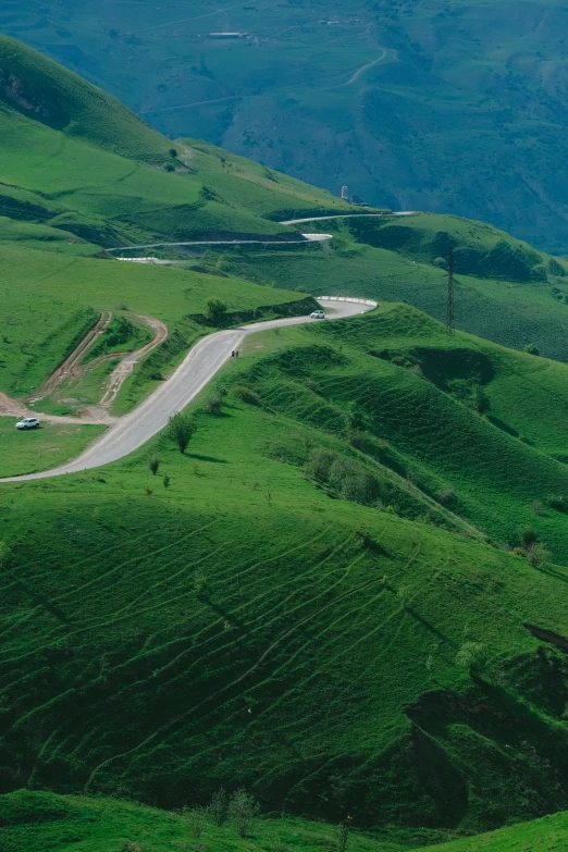 a road going down an open green hillside