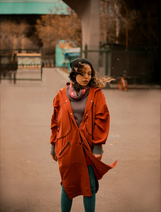 a person wearing an orange jacket and green pants