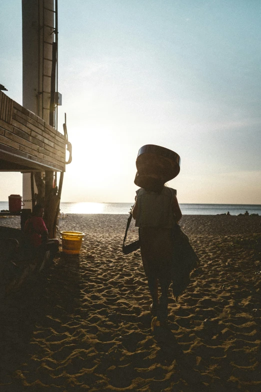 a little boy with his hat and bag on the beach