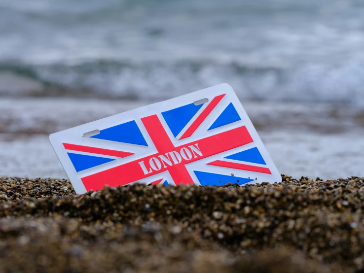 a british flag sticker is laying on the sand