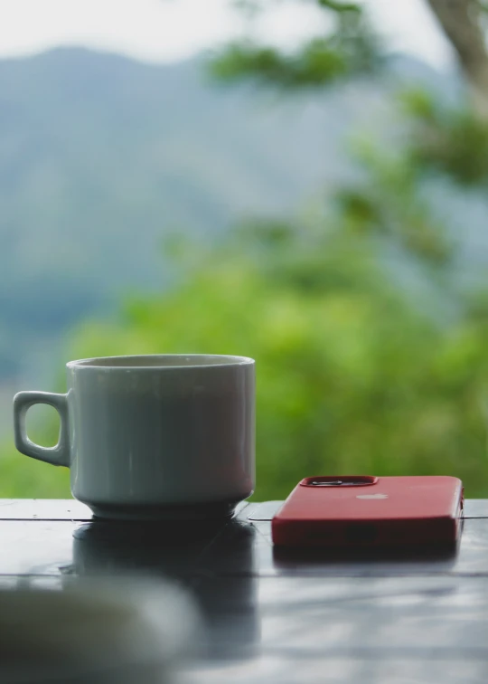 coffee cup with a cell phone next to it