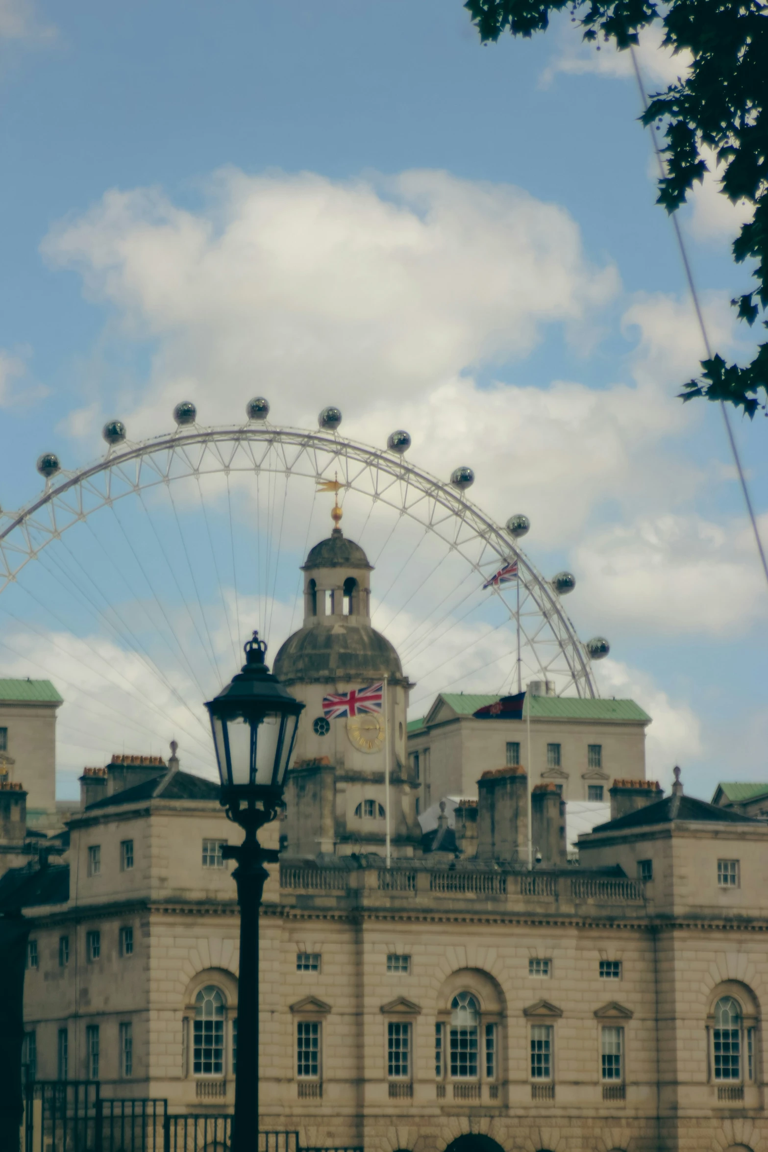 the large ferris wheel is over the street lamp