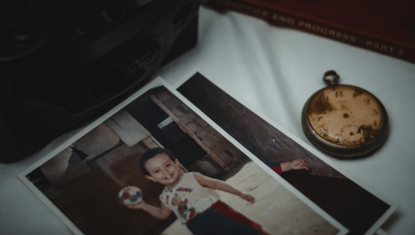 a little boy standing next to a couple of pictures