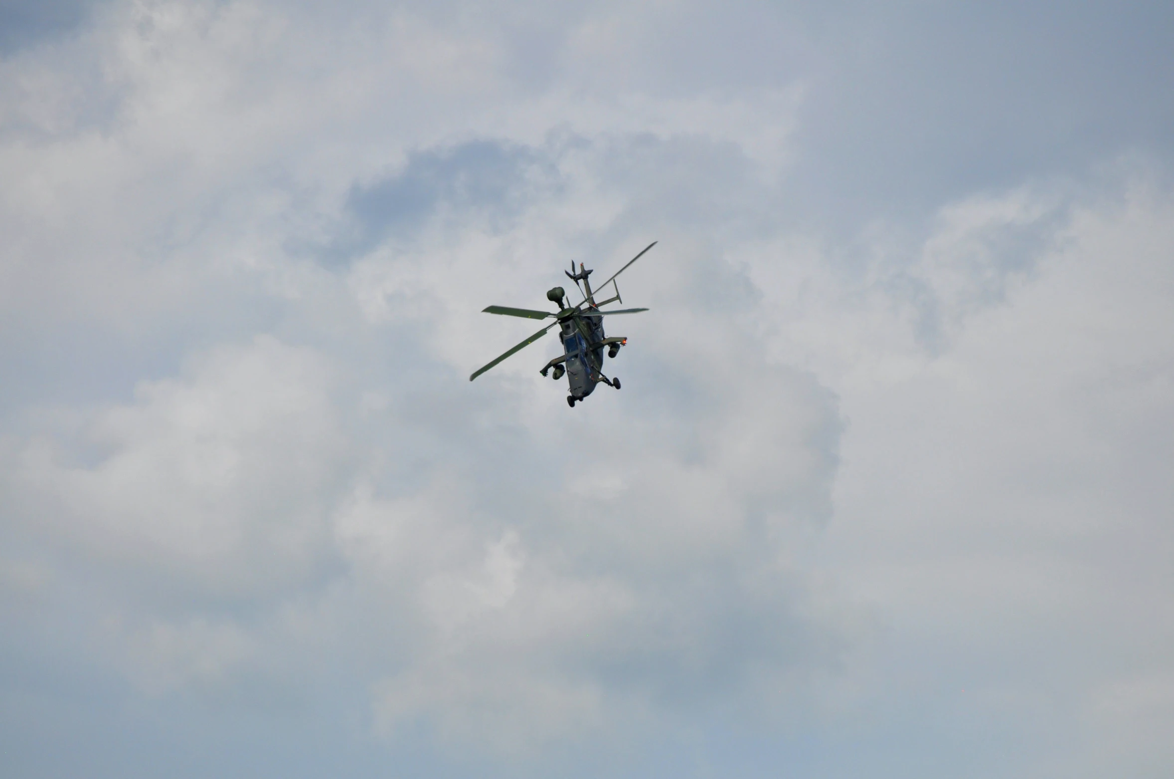 an army helicopter is flying high in the sky