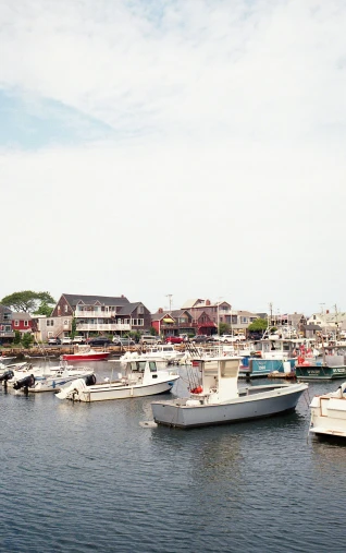 a harbor with boats, buildings and homes in the background