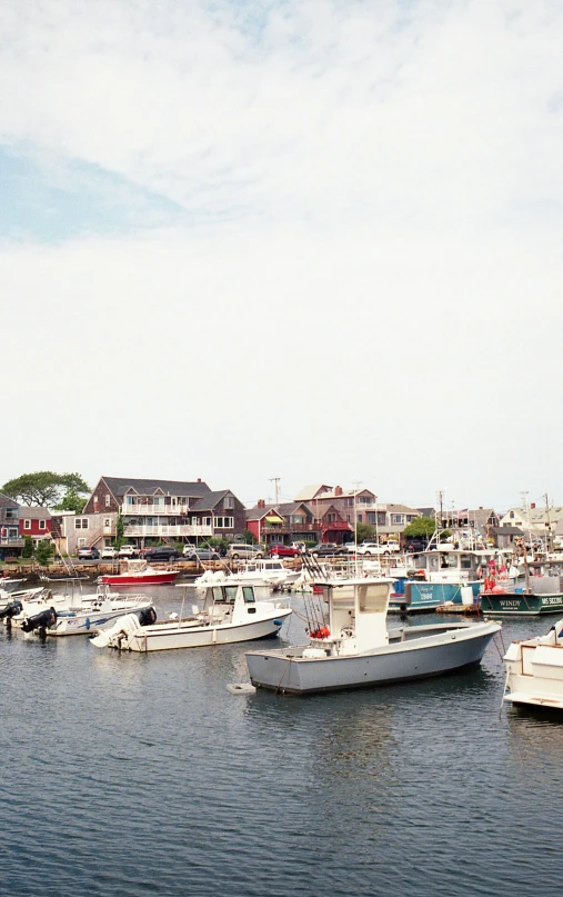 a harbor with boats, buildings and homes in the background
