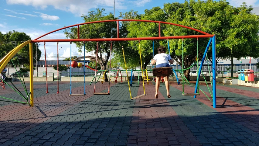 two s play in the playground, one standing on a rope