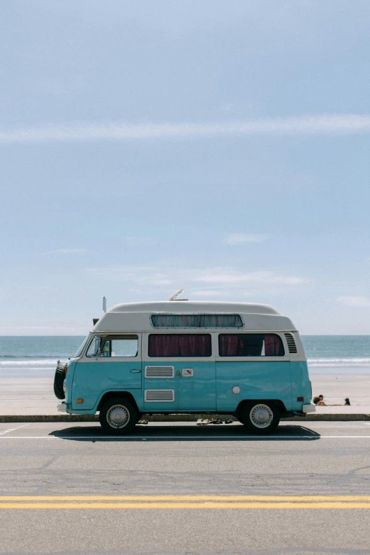 a blue and white bus parked on a road