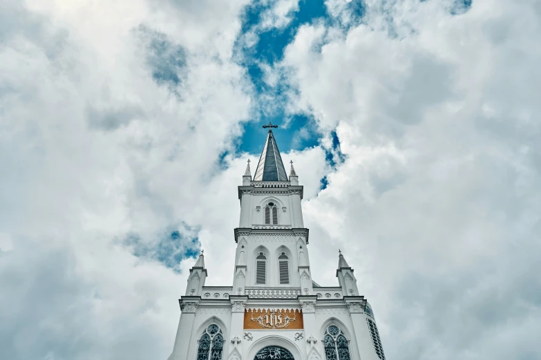 the clock tower is very tall and has a cross on top