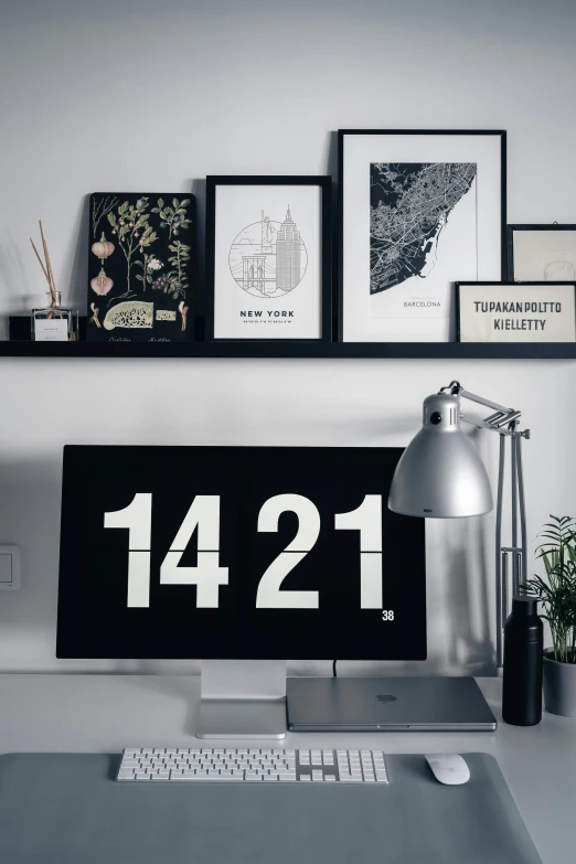 a desktop computer sitting on top of a desk under some pictures