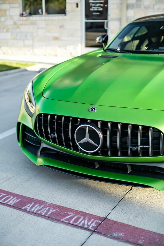 a shiny green sports car parked on the sidewalk