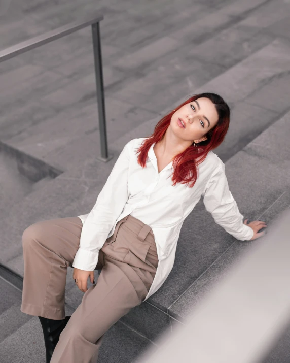 a woman with red hair sitting on stairs