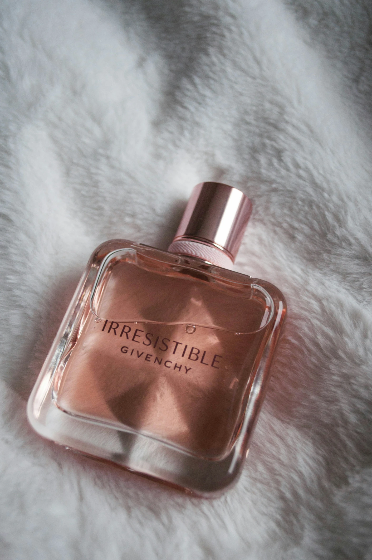 an open bottle of perfume on a fur covered surface