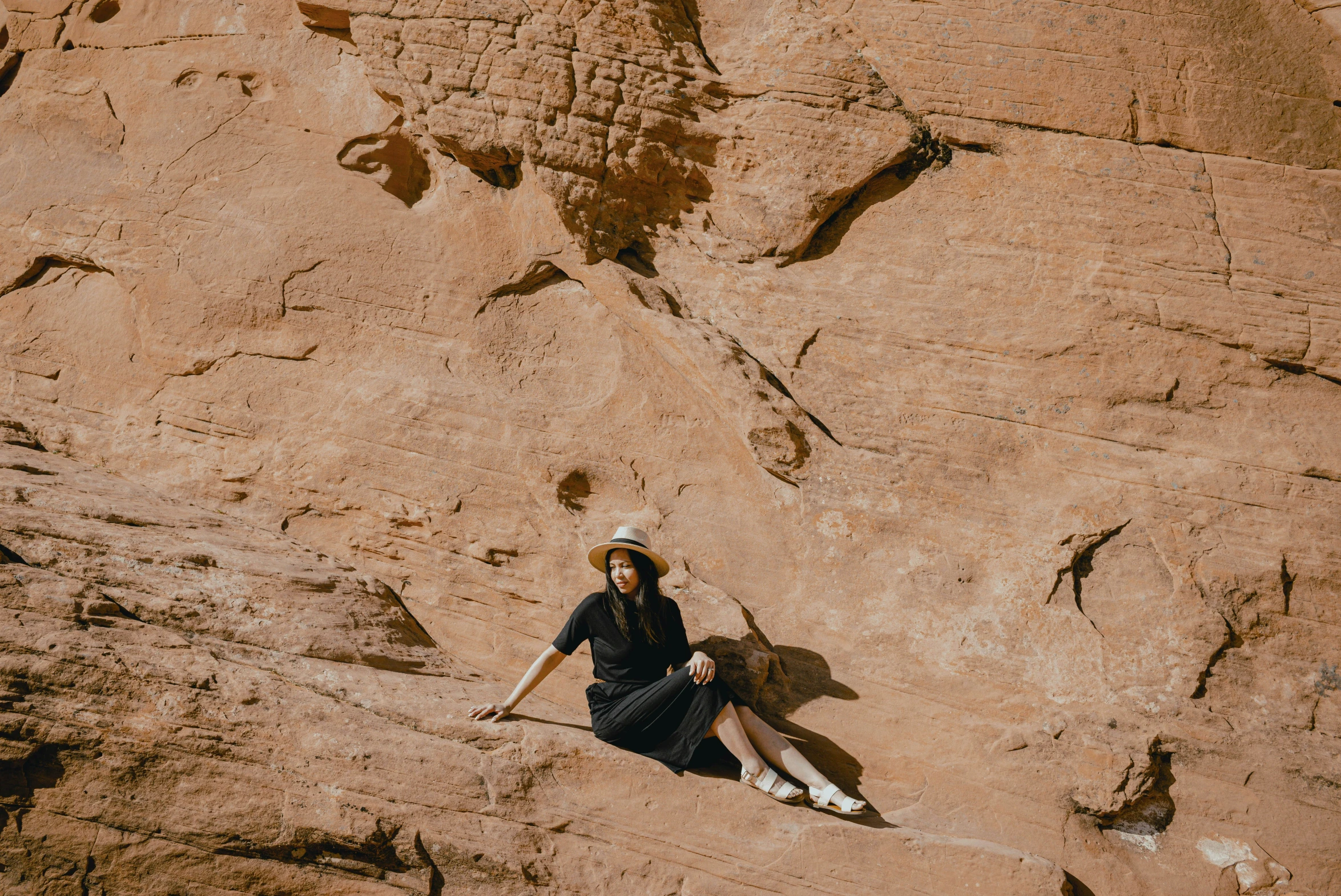 a woman sitting in a mountain holding a surfboard