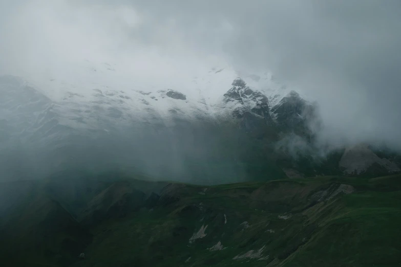 the fog covered mountains on a cloudy day