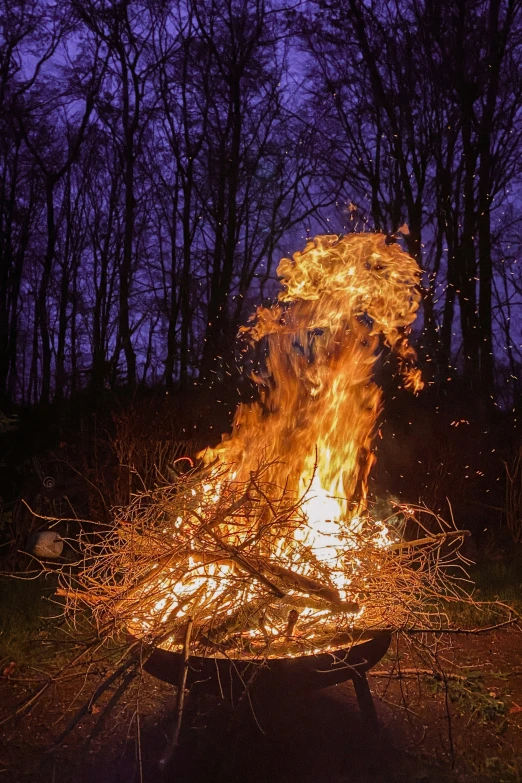 the fire is lit up by torches in the dark