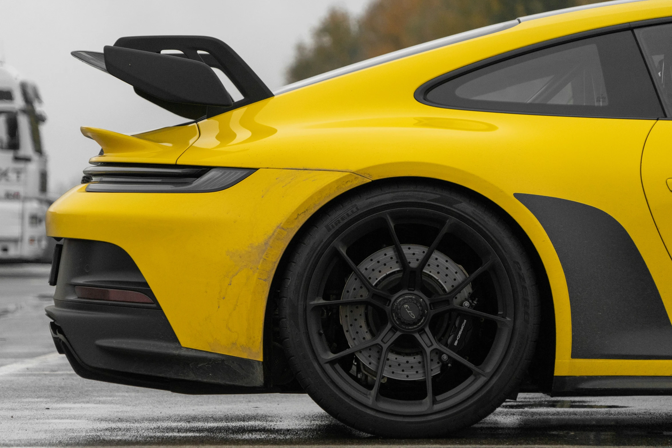 a yellow sports car in the rain