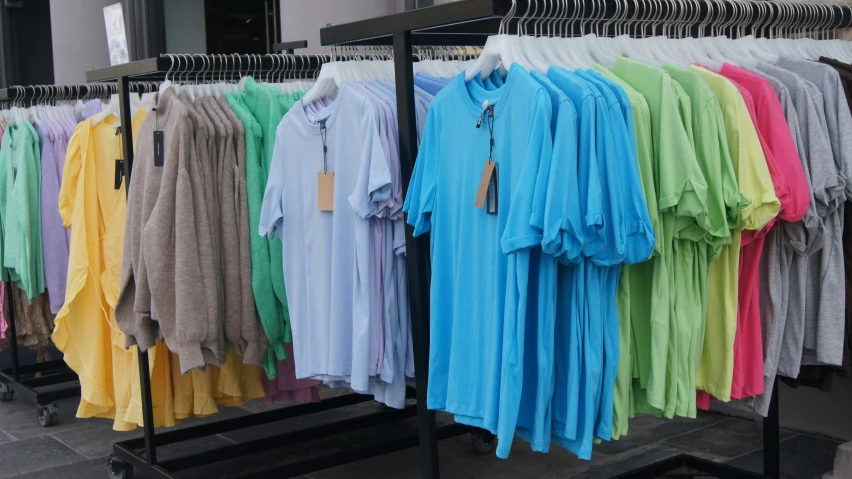 a rack full of colorful sweaters in a store