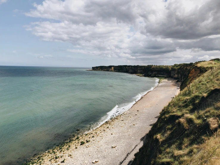 an empty beach with a boat on the water