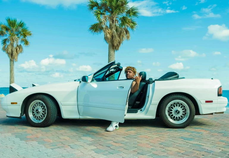 the man is sitting in the white car next to the ocean