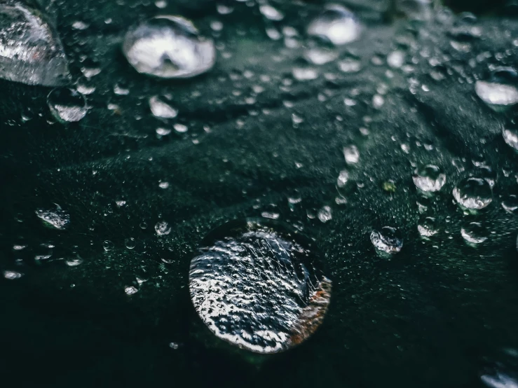 drops of water that are sitting on a black object