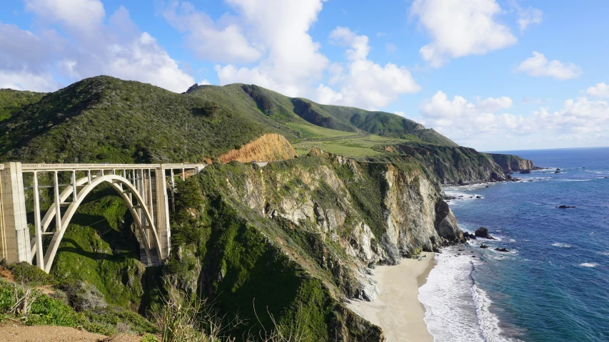 a very long bridge over some water and a big hill