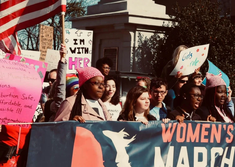 women's march parade in washington dc with many signs and people