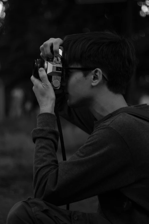 a black and white po of a person holding up a camera