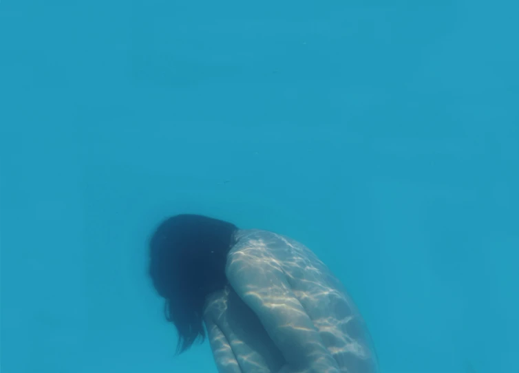 woman is diving through the water in the blue water
