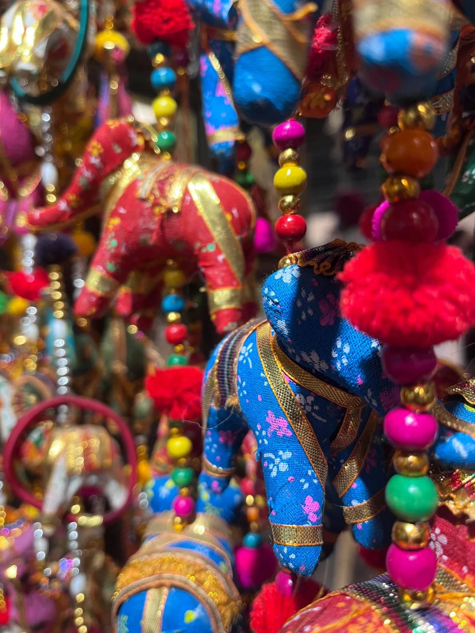 colorfully dressed items hang in rows of small ornaments