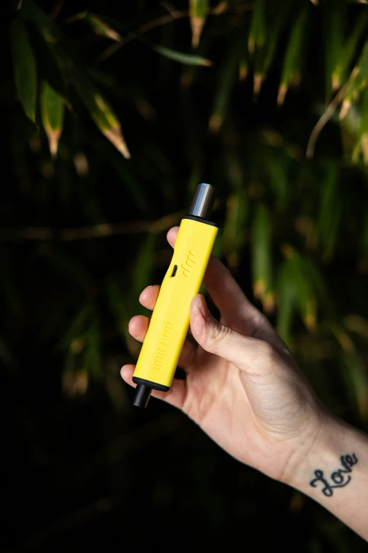 a person holding a small yellow device in their hand