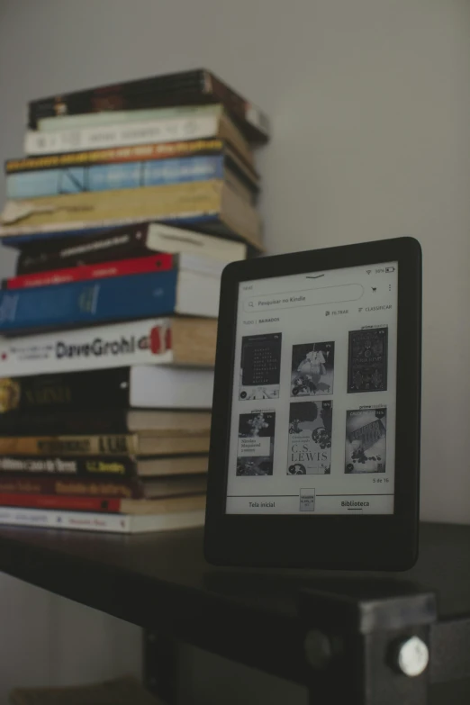 a tablet next to some books stacked up