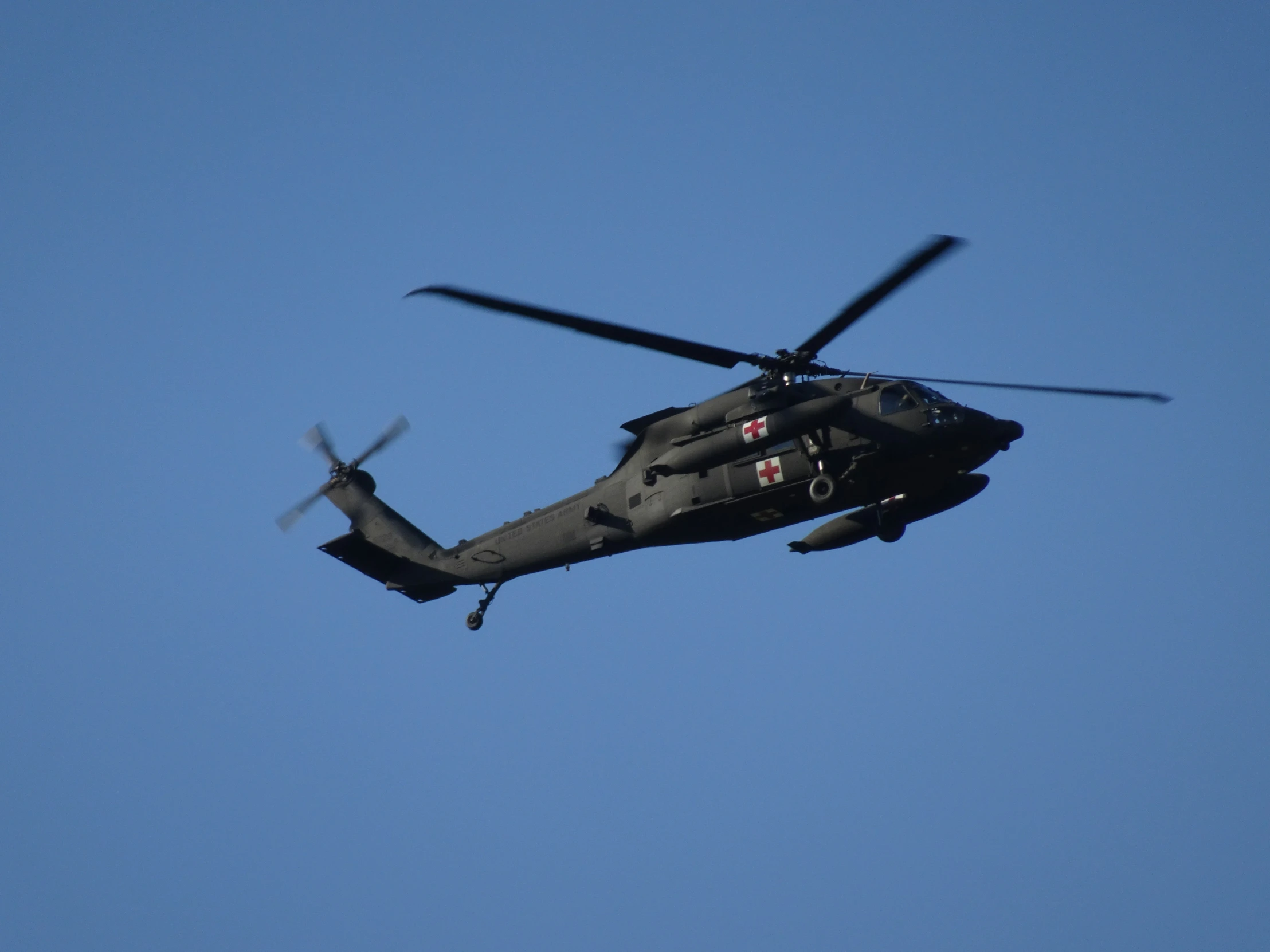 a helicopter flying high in the blue sky