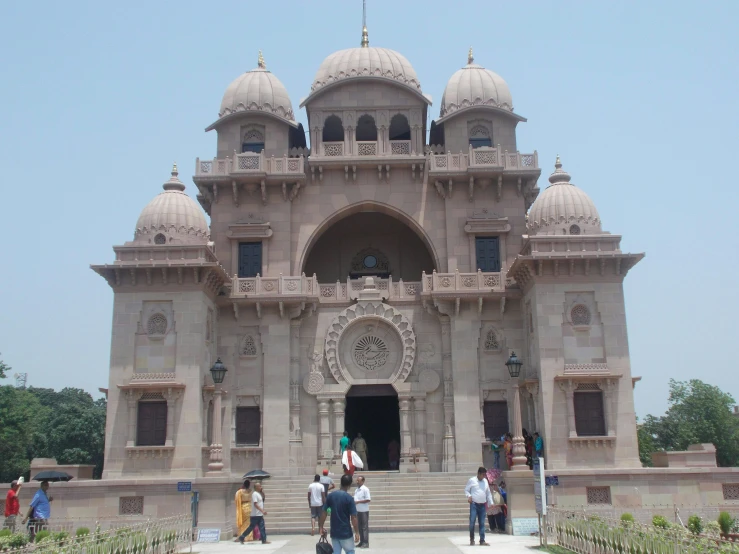 the building has white walls and many people standing outside