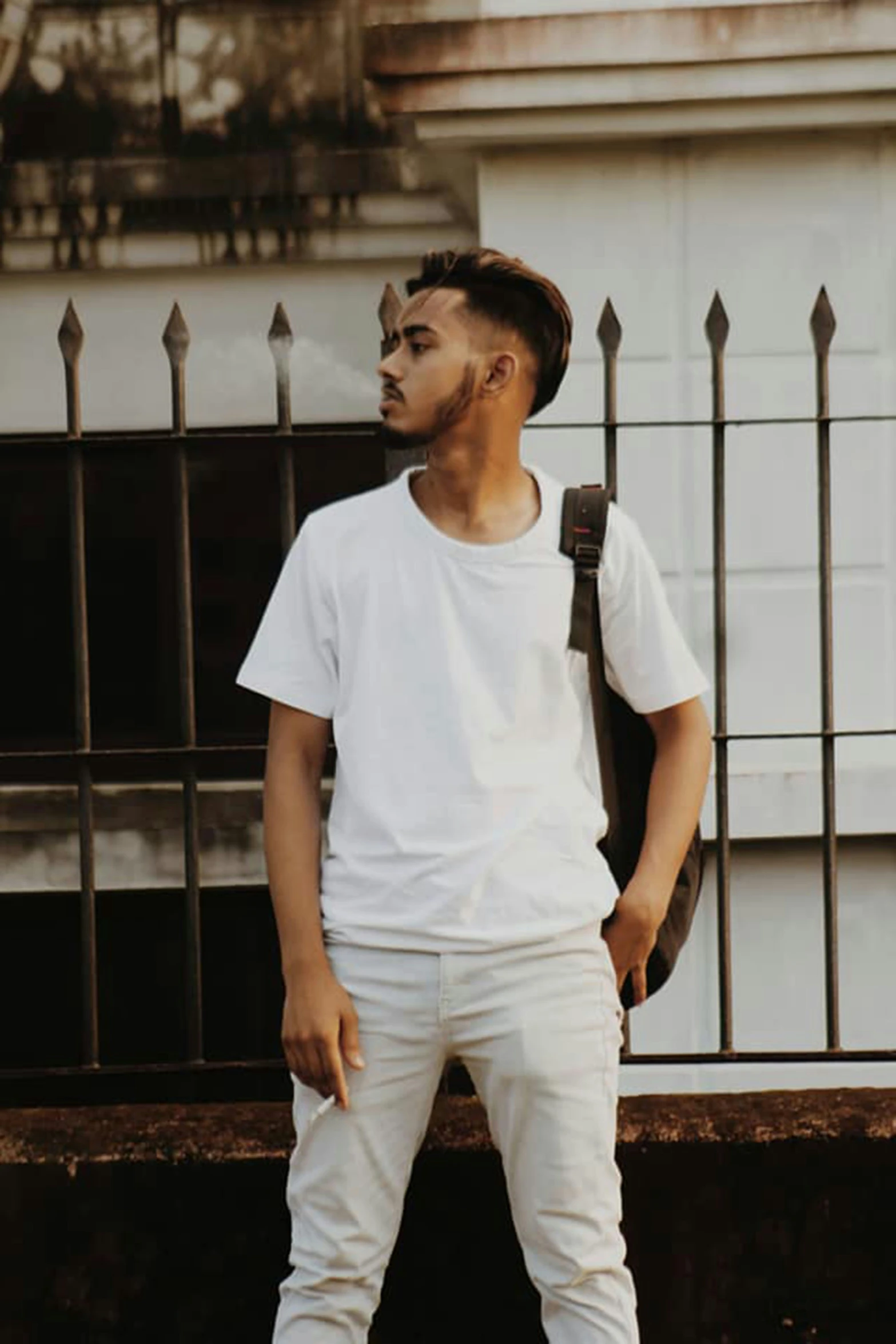 a man standing in front of some iron fence