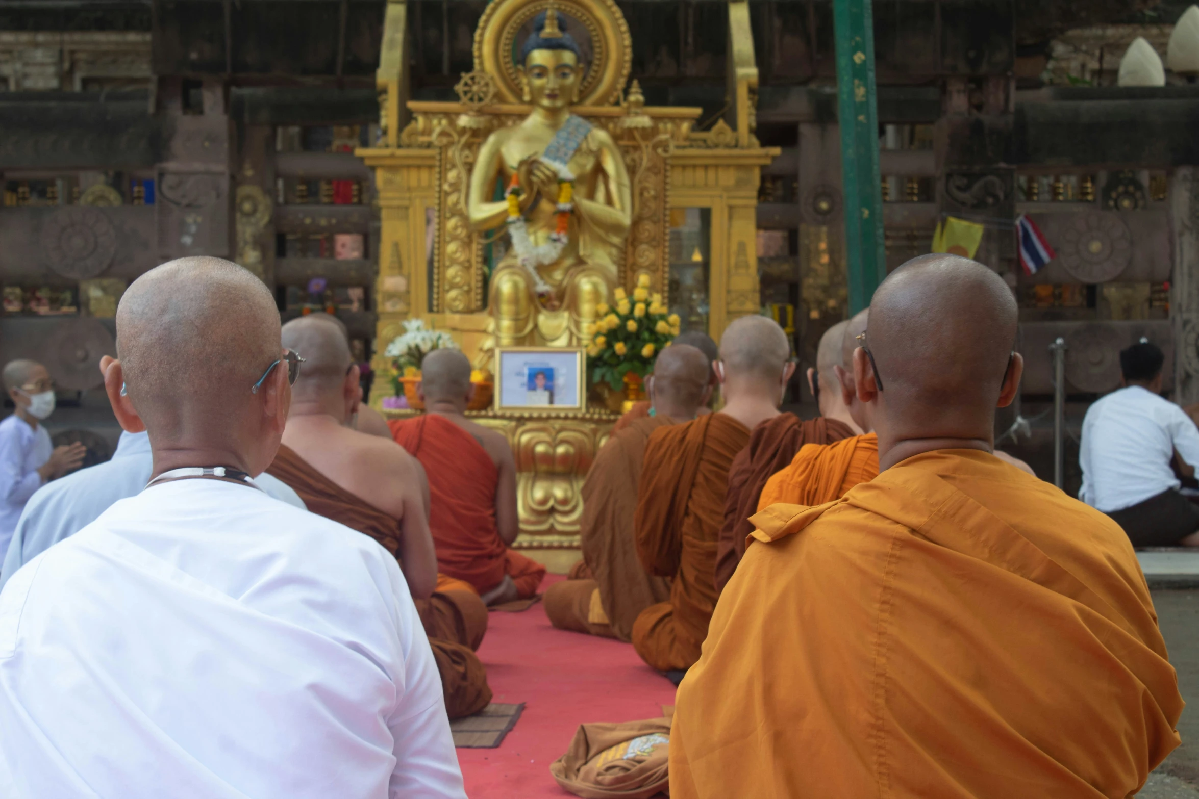 a group of men sitting in a buddhist room