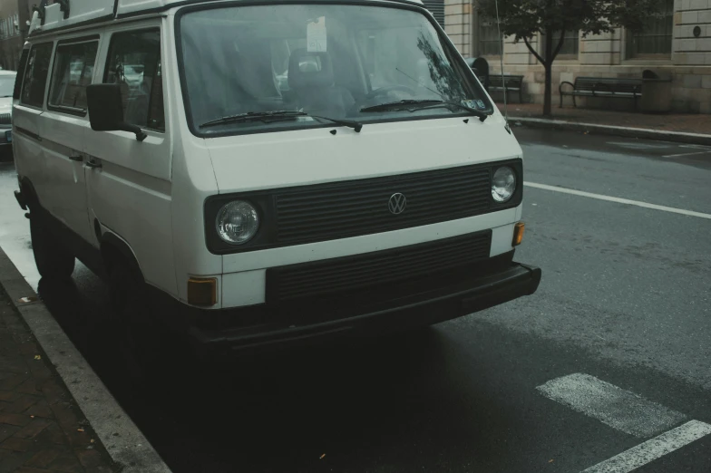 white van parked in front of building on a rainy day
