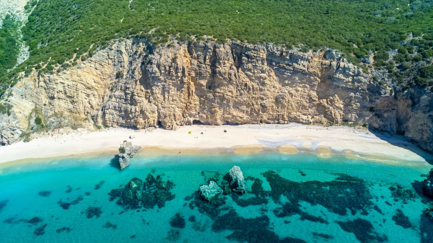 an aerial po of two rocks and blue water