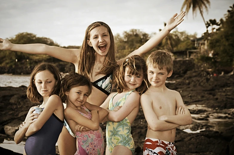 a group of children standing on the beach