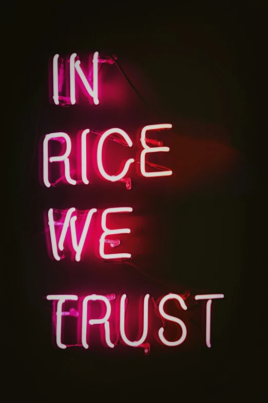 a neon sign that reads in rice we trust