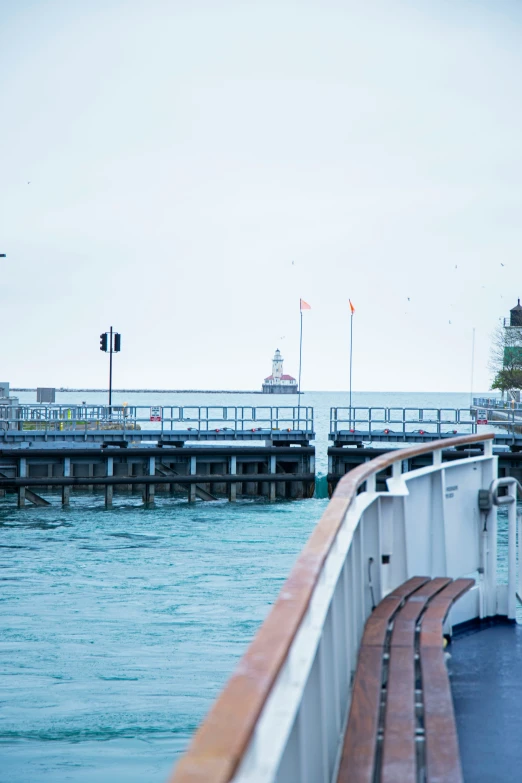 a boat sails down a harbor towards a long pier