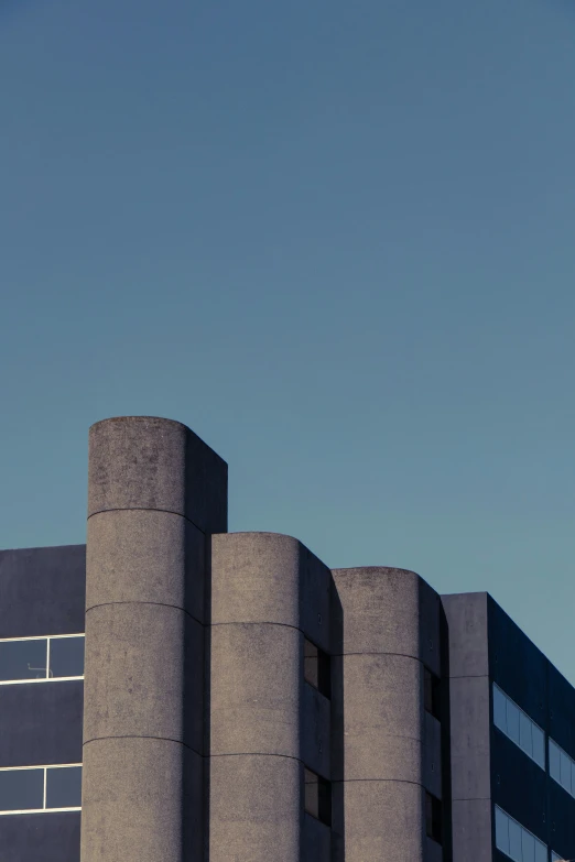 a plane flying over a concrete building with a clock on the tower