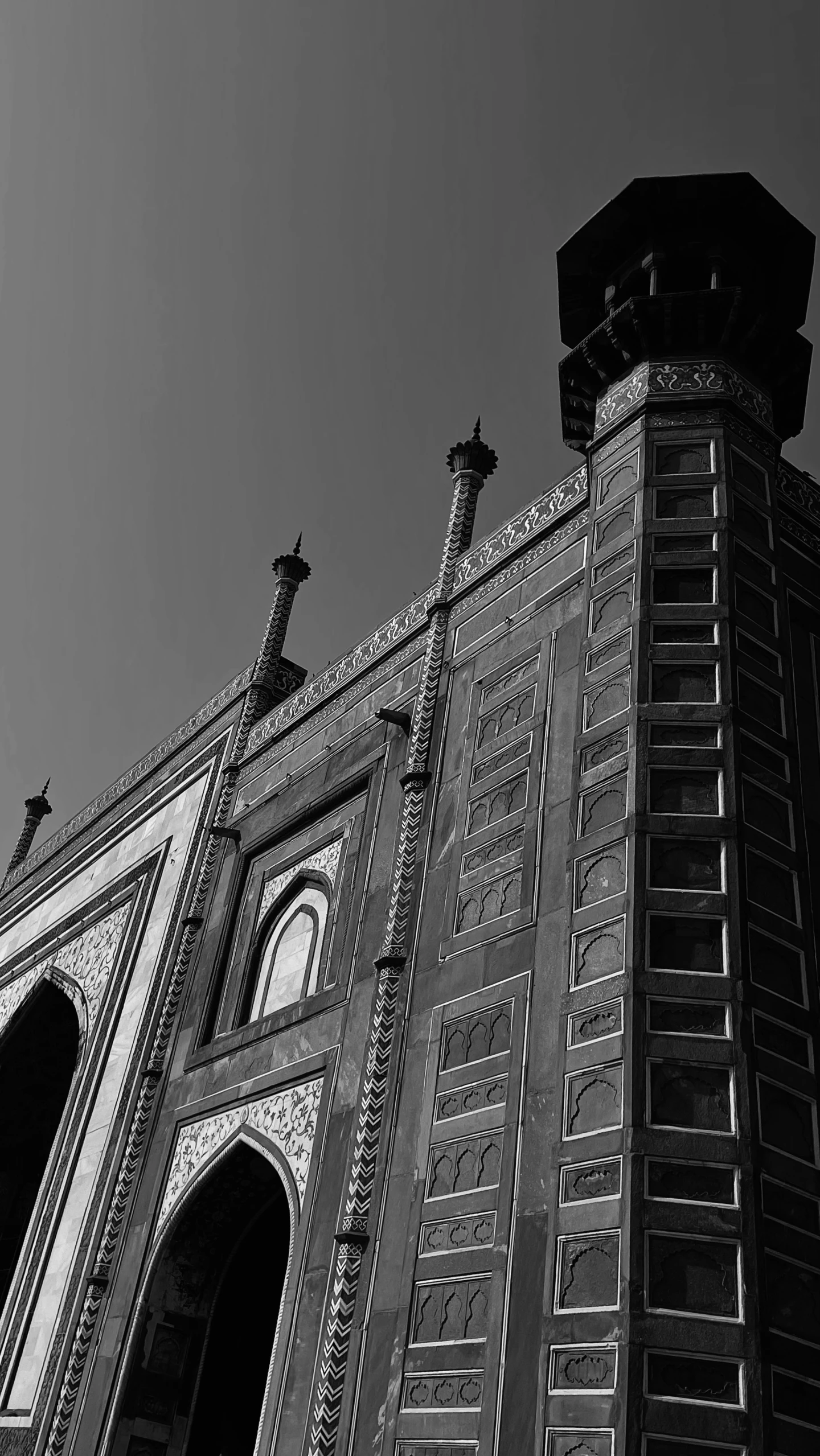 a tall building with some arched doorways under a blue sky