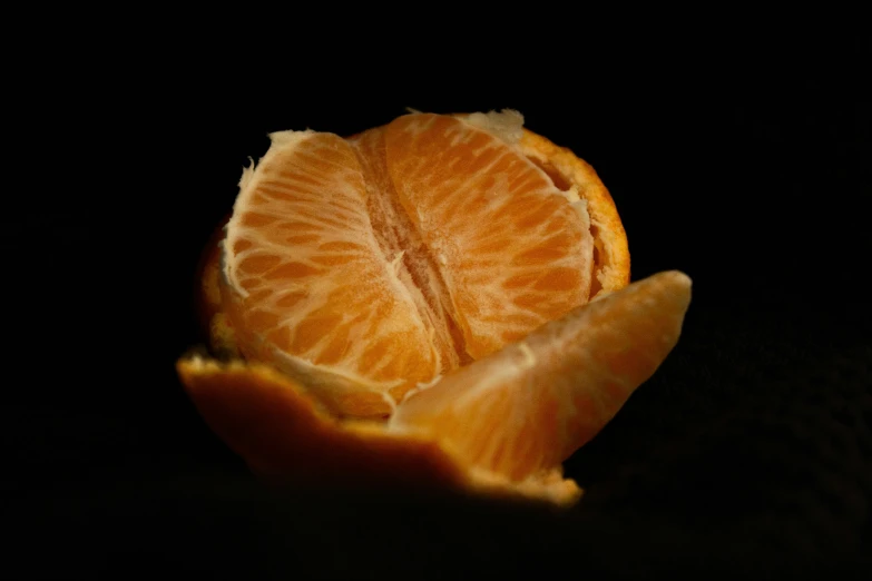 an orange cut in half in the middle of its peel