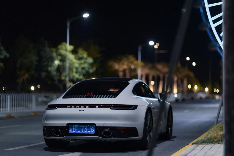 a white sports car at night with lights on